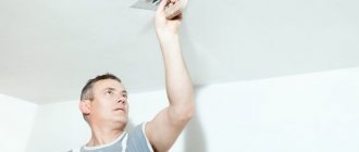 Маляр наносит шпатлевку на потолок в квартире