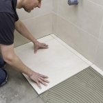 Why do tilers wet the floor before laying and what happens if they overdo it?